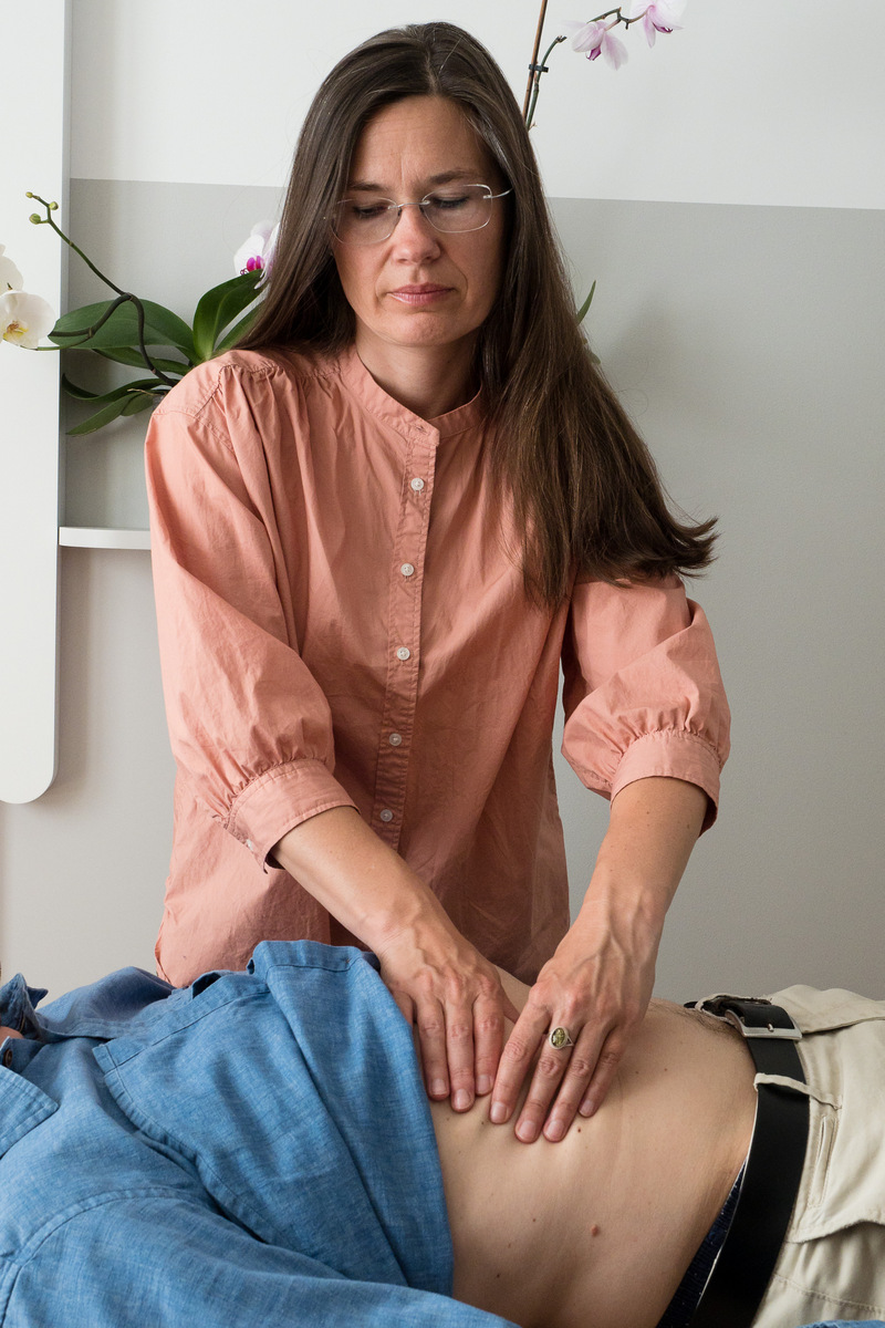 woman doing hara palpation on abdomen of laying patients