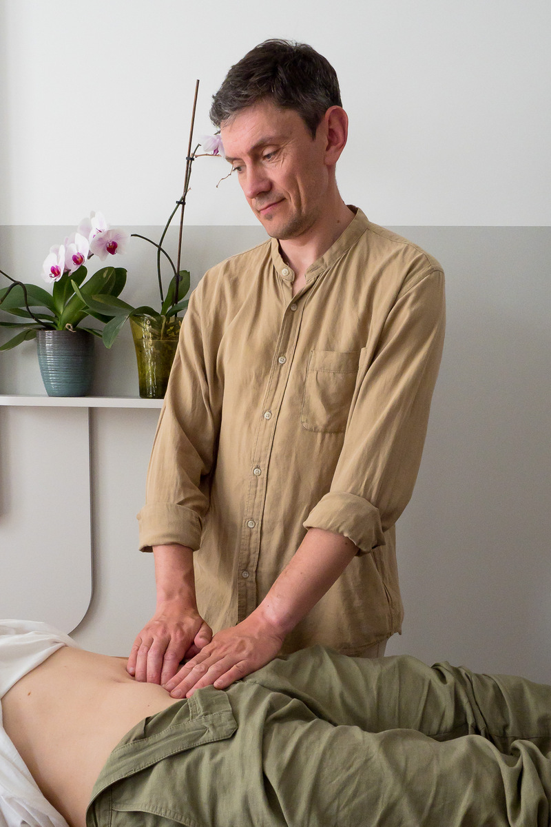 woman doing hara palpation on abdomen of laying patients